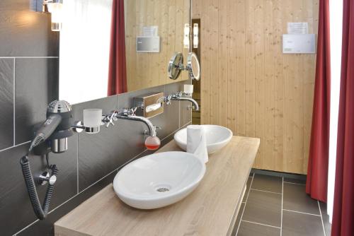 bagno con 2 lavandini e asciugacapelli di Resort Deichgraf Resort Deichgraf 27-01 a Wremen