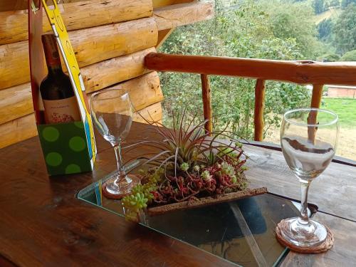 una mesa con dos copas y una botella de vino en Glamping El Ocaso en Zipaquirá
