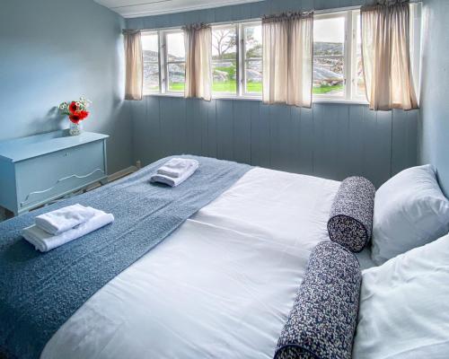 a bedroom with a large bed with two towels on it at Portør Pensjonat in Kragerø