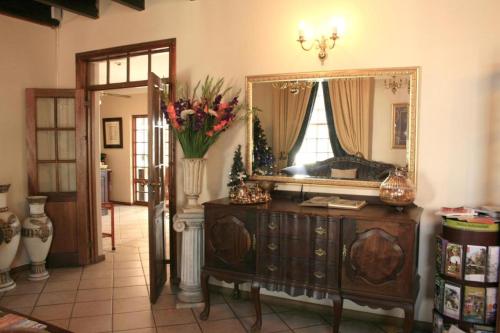 a room with a mirror and a dresser with flowers on it at Room in Guest room - Brooklyn Guesthouses in Pretoria