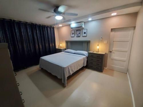 Schlafzimmer mit einem Bett und einem Deckenventilator in der Unterkunft Suite at the Courtleigh Towers in Kingston