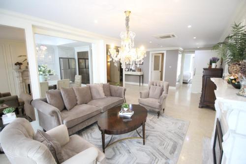 a living room with a couch and chairs and a table at SASHA HOUSE in Ban Yang