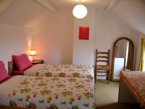 a bedroom with two beds and a chair at Stargaia Retreat in Glastonbury