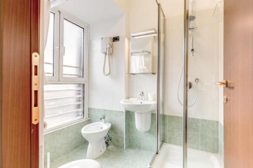 a bathroom with a toilet and a sink and a shower at Hotel Flavio in Rome
