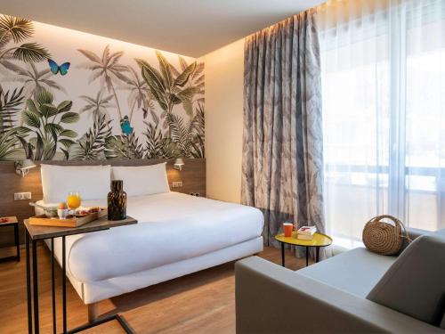 a hotel room with a bed and a couch at ibis Styles Beaulieu sur Mer in Beaulieu-sur-Mer