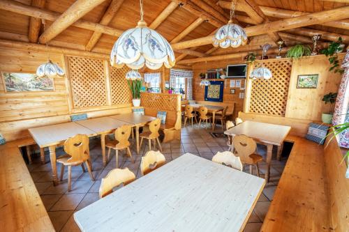 ein Esszimmer mit Tischen, Stühlen und Kronleuchtern in der Unterkunft Almbauer Morgenbesser in Trattenbach