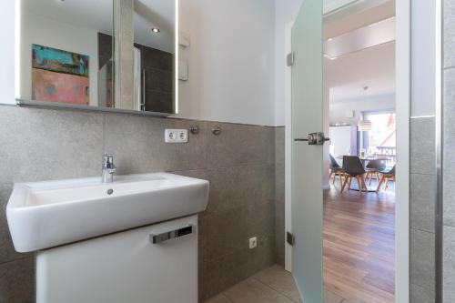 un baño con lavabo y espejo en Dorfplatz Appartement Dorfplatz, en Olsdorf
