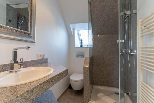 ein Bad mit einem Waschbecken, einem WC und einer Dusche in der Unterkunft Kleinod Appartement Stina in Sankt Peter-Ording