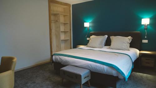 - une chambre avec un grand lit aux murs bleus dans l'établissement Jeux de Goûts, à Hérissart