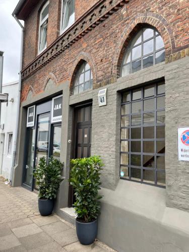 a brick building with two potted plants in front of it at Apartment Factory in Hamburg