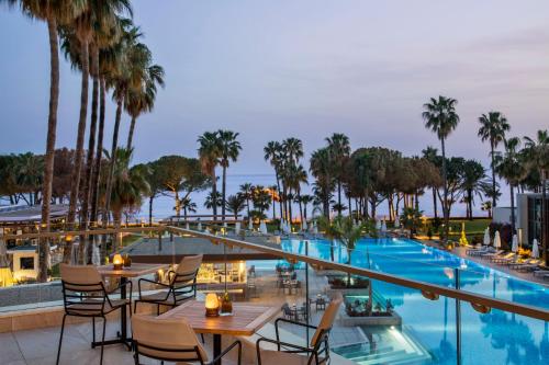 a hotel patio with tables and chairs and a swimming pool at Acanthus Cennet Barut Collection - Ultra All Inclusive in Side