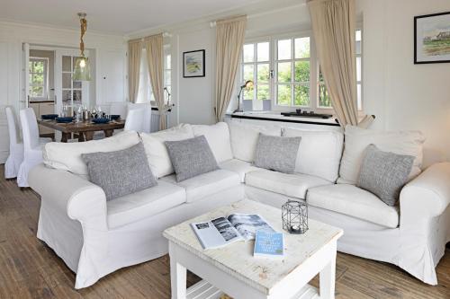 uma sala de estar com um sofá branco e uma mesa em Syltbeach em List
