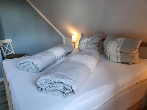 duże białe łóżko z poduszkami i lampą w obiekcie Ferienwohnung 3 in der Waldstraße w mieście Sankt Peter-Ording