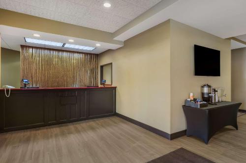 a waiting room with a bar and a tv on the wall at MainStay Suites Fitchburg - Madison in Madison