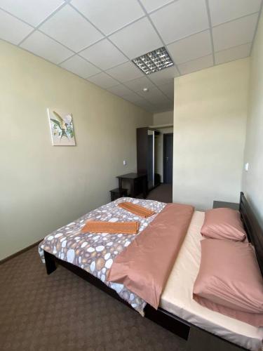 ein Zimmer mit einem Bett mit rosa Kissen darauf in der Unterkunft Ластівка in Chust