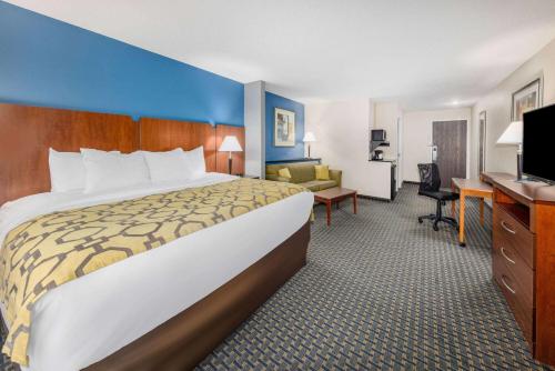 a hotel room with a large bed and a desk at Baymont by Wyndham Pratt in Pratt