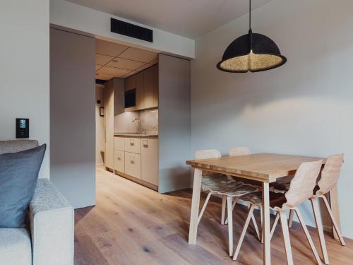 uma cozinha e sala de jantar com uma mesa de madeira e cadeiras em Åhus Seaside em Åhus