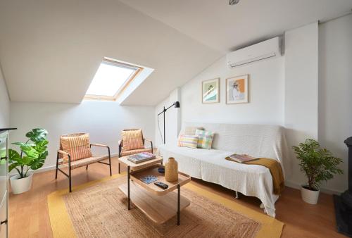 a living room with a bed and two chairs at Bright Apt w Balcony, AC, Parking, By TimeCooler in Lisbon