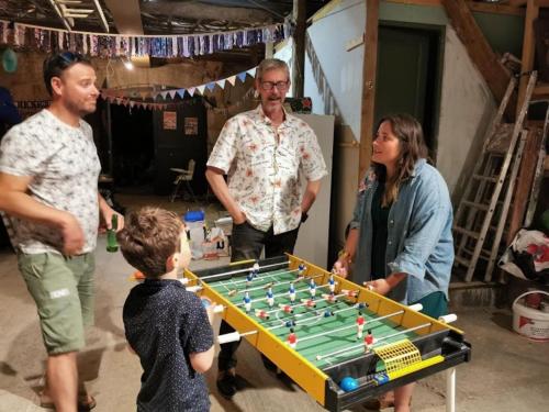 a group of people standing around a foosball table at La Calade in Montouliers