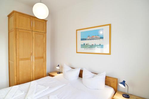 ein Schlafzimmer mit einem weißen Bett und einem Schrank in der Unterkunft Hamburg App. 05 in Ahlbeck