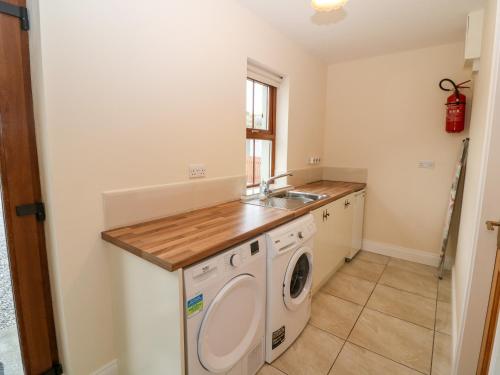 a laundry room with a washing machine and a sink at Ballycahane in Castletownshend