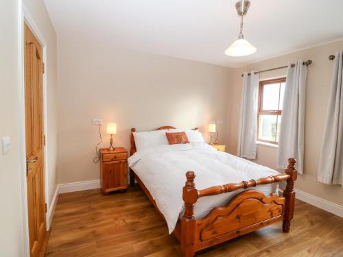 a bedroom with a large bed and a window at Ballycahane in Castletownshend