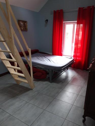 a bedroom with a bunk bed and red curtains at Studio à Theuville-Baigneaux in Theuville