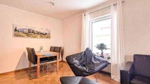 a living room with a table and chairs and a window at Ferienwohnung Foetibus in Füssen