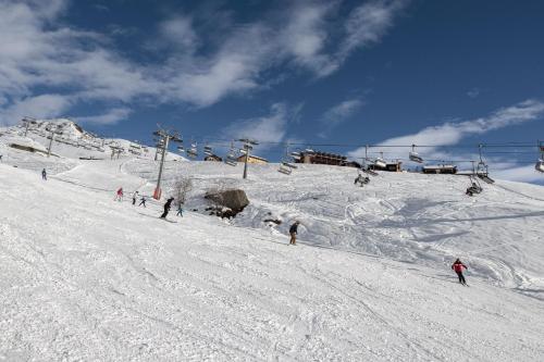 a group of people skiing down a snow covered slope at HelloChalet - Pandora Mountain View with jacuzzi, garage and ski storage in Breuil-Cervinia