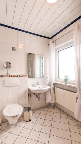 a white bathroom with a toilet and a sink at Ferienwohnung Foetibus in Füssen