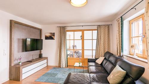 a living room with a couch and a television at Beim Straußer in Schwangau