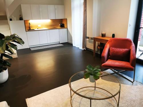 uma sala de estar com uma cadeira vermelha e uma mesa em Ô'date gîte &spa em Nantes