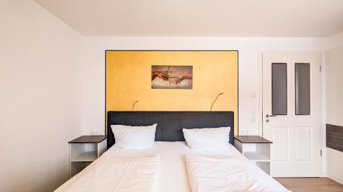 シュヴァンガウにあるBeim Straußerのベッドルーム1室(白い大型ベッド1台、テーブル2台付)