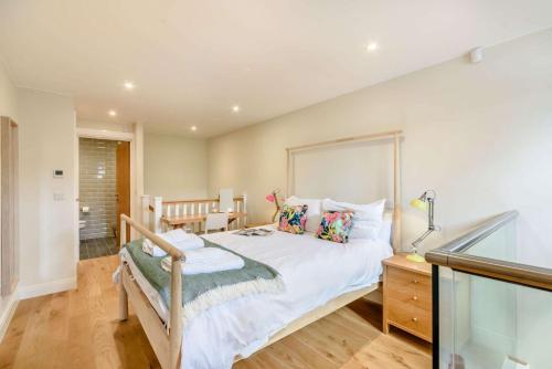 1 dormitorio con 1 cama grande y 1 mesa en The Trinity, en Stow on the Wold