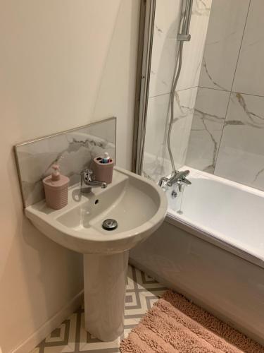 La salle de bains blanche est pourvue d'un lavabo et d'une baignoire. dans l'établissement City Blessed Apartment 4 with free parking, à North Shields