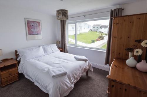 a bedroom with a bed and a large window at 34 Surfview Beach House in Newquay