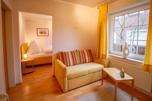 ein Wohnzimmer mit einem Sofa und einem Fenster in der Unterkunft Teewulkje in Greetsiel
