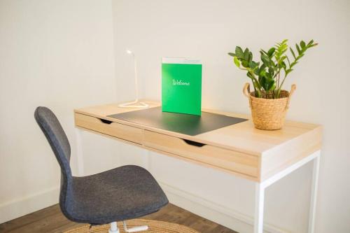 a desk with a chair and a book and a plant at Lovely 3 Bedroom Apartment in Eindhoven 65m2 - SD23N in Eindhoven