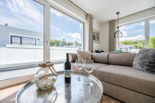 a living room with a glass table with two wine glasses at Villa Zweite Heimat - Exklusive Penthouse No 4 in Lohme