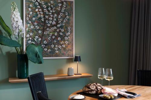 a dining room table with wine glasses and a painting at Villa am Schloss Ranzow L3 Lohme Luxury Living in Lohme