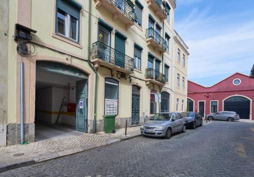 una calle con coches estacionados frente a los edificios en Bright Apt w Balcony, AC, Parking, By TimeCooler, en Lisboa