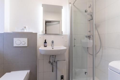 a white bathroom with a sink and a shower at Strandglueck in Westereck