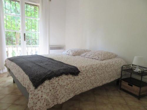 ein Schlafzimmer mit einem Bett mit einer Decke darauf in der Unterkunft Maison indépendante sur notre propriété in Hyères