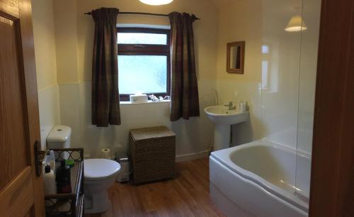 a bathroom with a tub and a toilet and a sink at Arisaig B&B Lovely Double Room Sea & Island Views in Arisaig