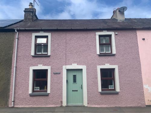 a pink house with a green door and windows at Min-Y-Fford sleeps 6 plus pet in Newport