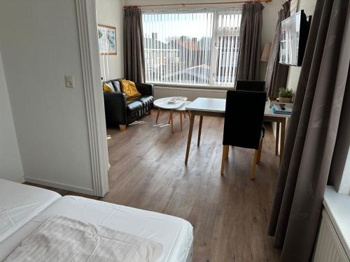 un soggiorno con letto, tavolo e sedie di Appartementen Beatrix a Domburg