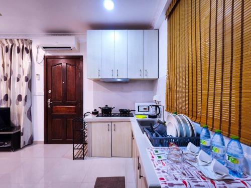 a kitchen with white cabinets and a counter with dishes at Reef Guest House in Male City