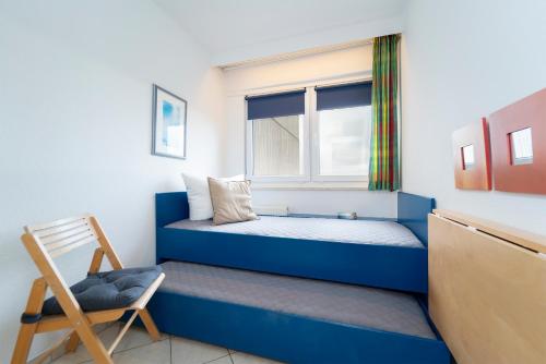 Un dormitorio con una cama azul y una ventana en Berolina Wohnung 706, en Dahme