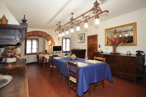 Palazzo Tarlati - Hotel de Charme - Residenza d'Epoca في سيفيتيلا إن فال دي تشيانا: غرفة طعام مع طاولة مع قماش الطاولة الزرقاء