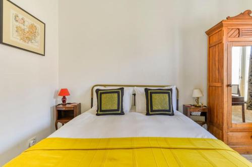 a bedroom with a bed with a yellow blanket on it at La Calade in Montouliers